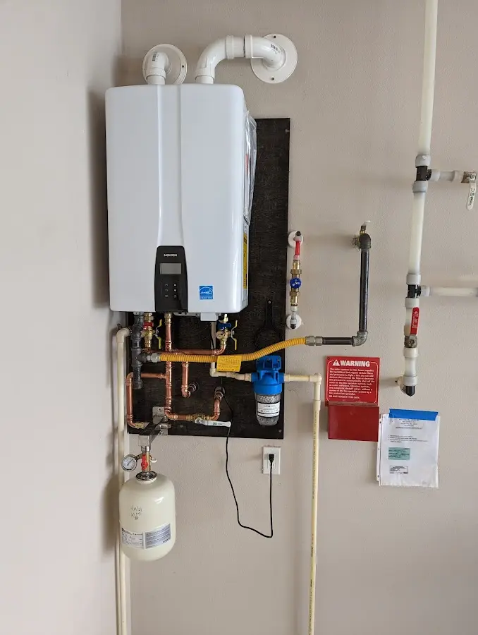 Professional plumber installing copper piping in a Manchester-by-the-Sea home